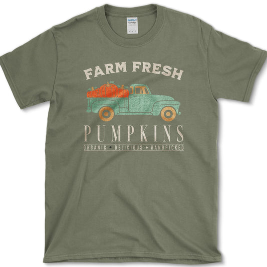 Vintage green pickup truck carrying orange pumpkins beneath Farm Fresh Pumpkins lettering