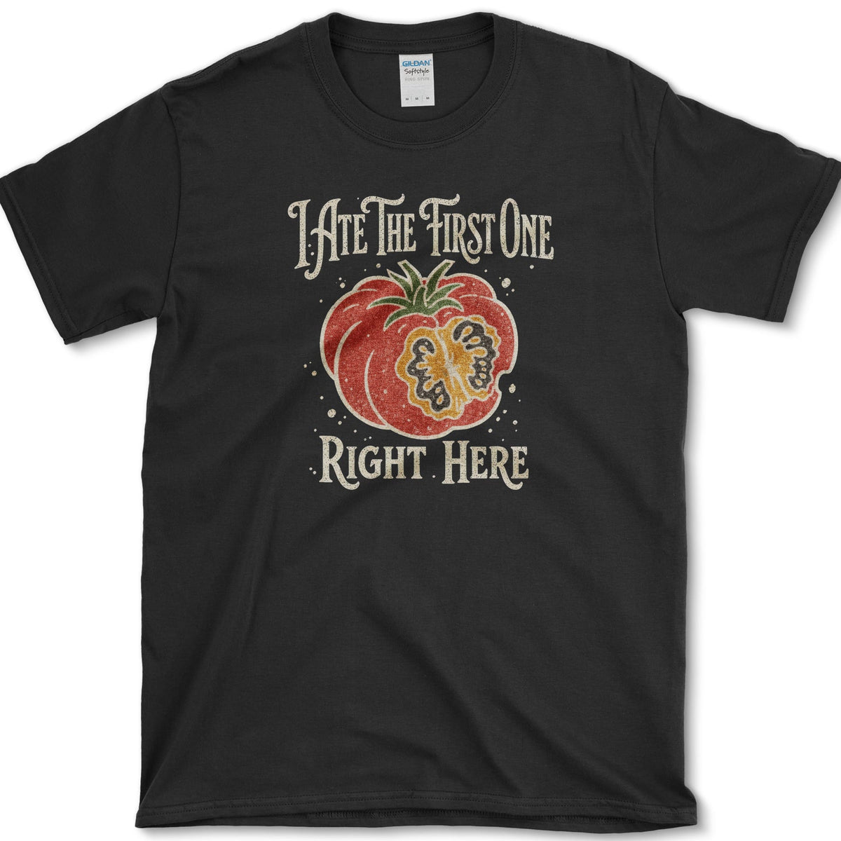 Ripe sliced garden tomato beneath I Ate the First One Right Here lettering on a T-shirt