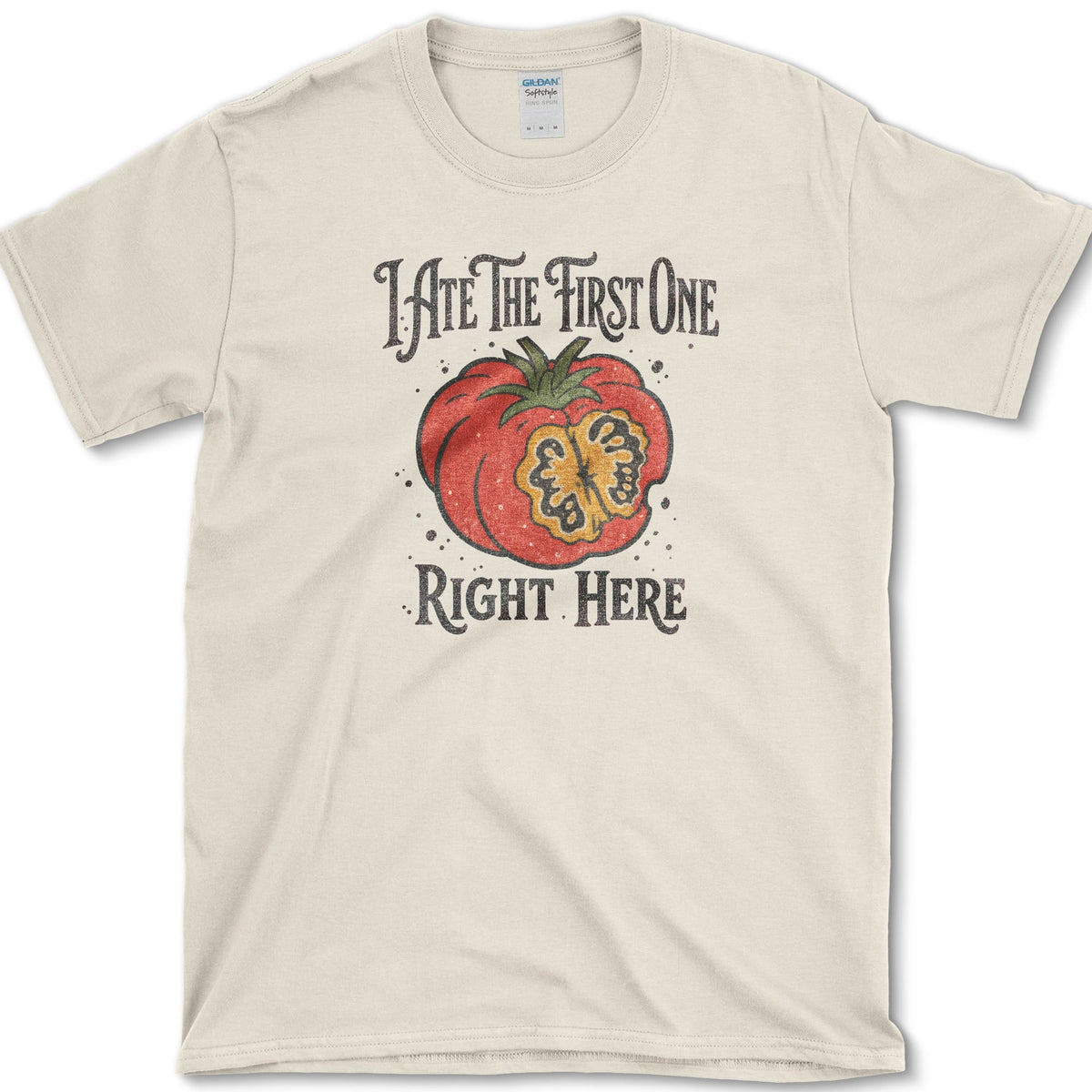 Ripe sliced garden tomato beneath I Ate the First One Right Here lettering on a T-shirt