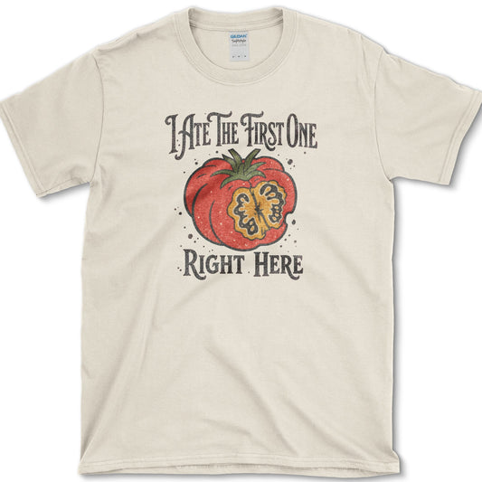 Ripe sliced garden tomato beneath I Ate the First One Right Here lettering on a T-shirt