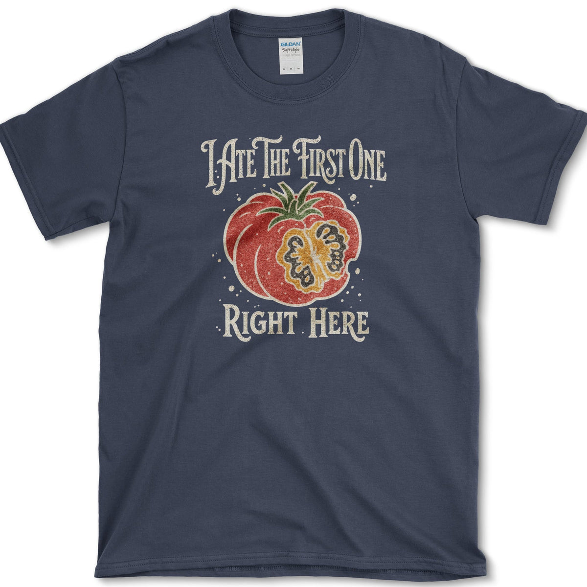 Ripe sliced garden tomato beneath I Ate the First One Right Here lettering on a T-shirt