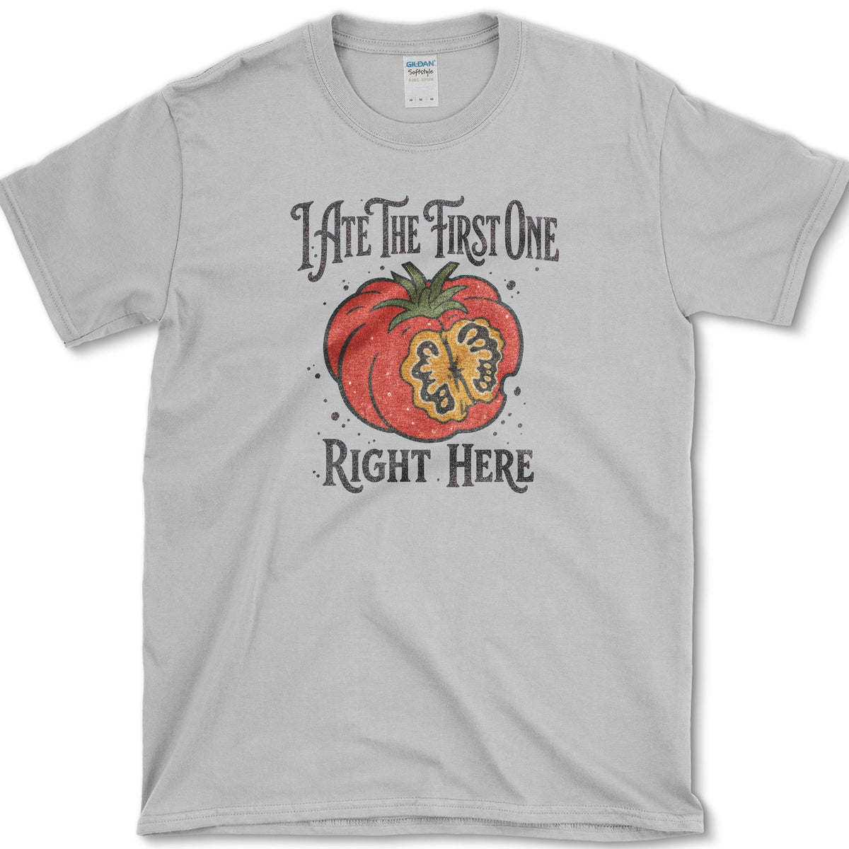 Ripe sliced garden tomato beneath I Ate the First One Right Here lettering on a T-shirt